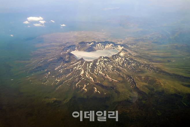 지난 13일 오전 연길공항에서 인천공항으로 가는 비행기 탑승 중 창가에서 바라본 백두산의 모습.