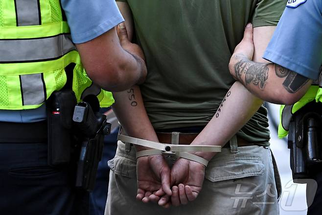 14일(현지시간) 일리노이주 시카고에서 노 킹스 데이 시위자가 경찰에 연행되고 있다. ⓒ 로이터=뉴스1 ⓒ News1 박형기 기자