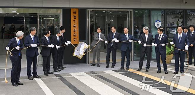 이한주(왼쪽 다섯 번째) 국정기획위원장과 국정기획위원회 진성준, 김용범, 방기선 부위원장 등 참석자들이 16일 서울 종로구 정부서울청사 창성동 별관에서 열린 국정기획위원회 현판식에서 현판 제막을 하고 있다. (공동취재) 2025.6.16/뉴스1 ⓒ News1 신웅수 기자
