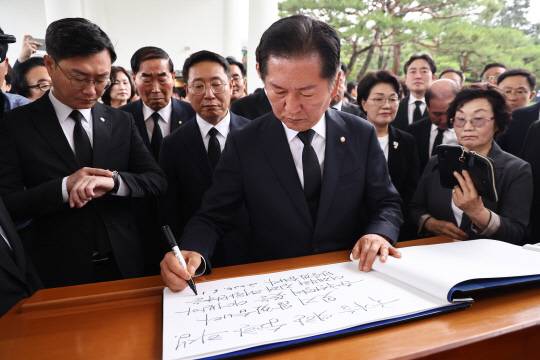 더불어민주당 차기 당대표 출마를 선언한 정청래 의원이 16일 오전 당 소속 의원들과 함께 서울 동작구 국립서울현충원 현충탑을 참배한 뒤 방명록을 작성하고 있다.<연합뉴스 사진>