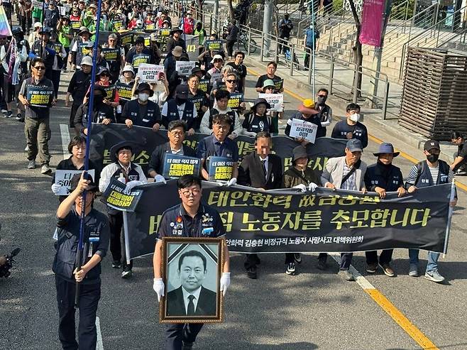 2025년 6월8일 발전 비정규직 노동자들이 선반 작업 중 회전체에 끼여 숨진 김충현(50)씨 영정을 들고 충남 태안 거리를 걷고 있다. 태안화력김충현대책위 제공