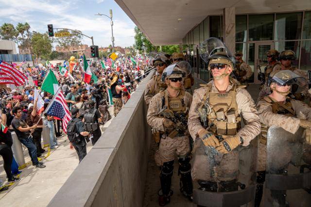 14일 미국 캘리포니아주 로스앤젤레스 연방 청사 앞에서 도널드 트럼프 미국 대통령을 규탄하는 시위대와 트럼프 행정부가 파견한 해병대원들이 대치하고 있다. 로스앤젤레스=EPA 연합뉴스