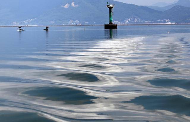 인천 영종도 바다 한가운데 낚싯대를 드리운 낚시꾼들 뒤로 파도가 몰려 들고 있다.