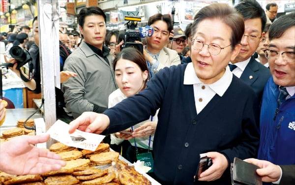 이재명 대통령이 대선 후보 시절 충북 단양 단양구경시장을 찾아 지역화폐로 떡갈비를 사고 있다.  연합뉴스