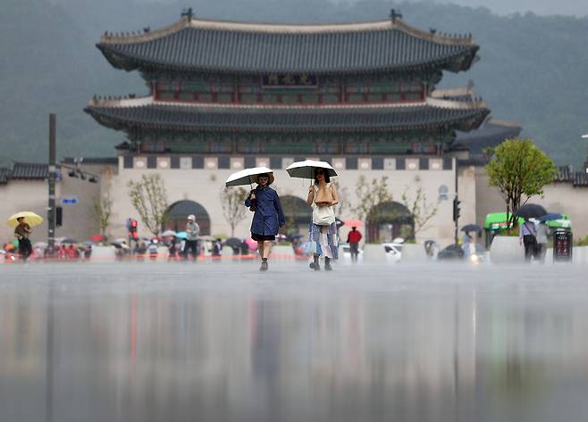 서울 지역에 소나기가 내린 16일 서울 광화문광장에서 우산을 쓴 시민이 길을 지나고 있다. 연합뉴스