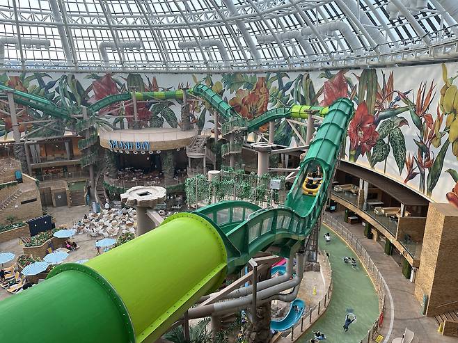 Two people ride a tube down Aqua Racer, a two-person slide, at Splash Bay inside Inspire Entertainment Resort. [WOO JI-WON]