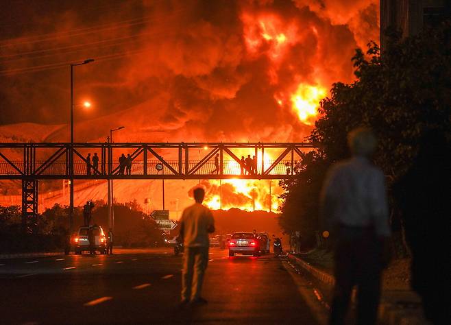 이스라엘이 15일 새벽(현지시간) 이란 수도 테헤란의 한 정유소를 공격한 가운데 피해를 입은 정유 시설에서 큰 불길과 연기가 치솟고 있다.  UPI연합뉴스