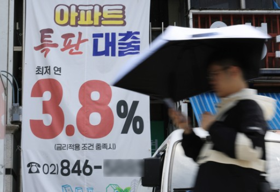 서울 시내 은행 앞 대출 홍보물을 지나는 시민. (출처=연합뉴스)