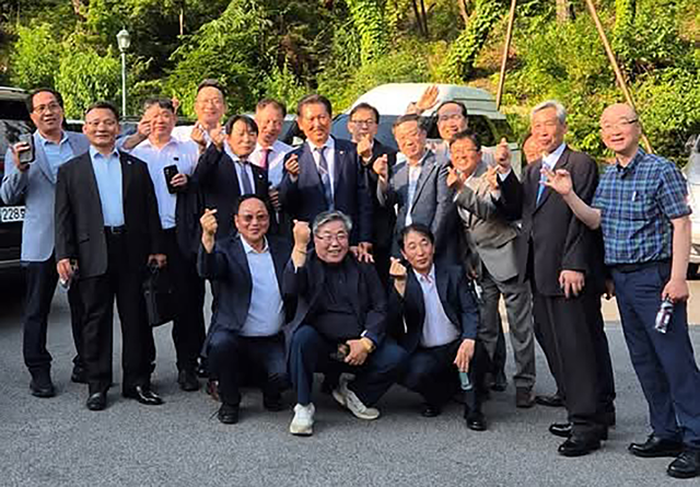 지난 14일 열린 이재명 대통령 장남 결혼식에 초대된 이 대통령의 소년공 시절 동료들이 정청래 더불어민주당 의원과 함께 기념사진을 찍고 있다.  정청래 의원 페이스북 캡처