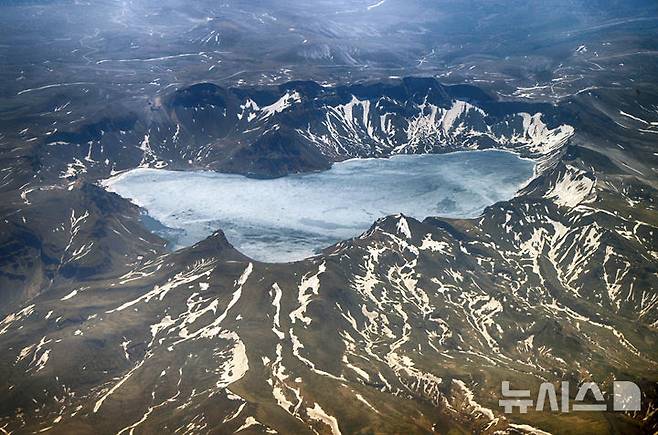 [옌볜=뉴시스] 정병혁 기자 = 지난 13일 연길공항 상공에서 인천공항으로 가는 비행기에서 바라본 백두산 천지가 장관을 이루고 있다. (공동취재) 2025.06.15. photo@newsis.com