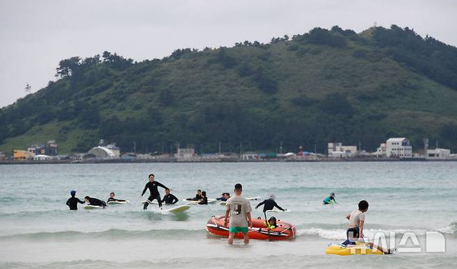 [제주=뉴시스] 우장호 기자 = 정체전선이 잠시 소강상태를 보인 15일 오후 제주시 한림읍 협재해수욕장을 찾은 관광객들이 물놀이를 하며 한낮 더위를 식히고 있다. 2025.06.15. woo1223@newsis.com