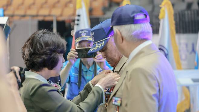 [서울=뉴시스] 강정애 국가보훈부 장관이 18일 오후 경기 수원시 장안구 수원실내체육관에서 열린 제27회 고엽제의 날 전우 만남의 장 행사에 참석해 참전용사 대표에게 제복을 입혀 드리고 있다. (사진=국가보훈부 제공) 2024.07.18. photo@newsis.com *재판매 및 DB 금지