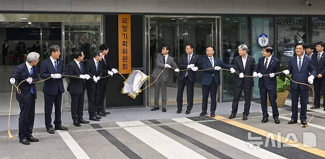 [서울=뉴시스] 김진아 기자 = 이한주(왼쪽 다섯번째) 국정기획위원회 위원장이 16일 서울 종로구 정부서울청사 창성동 별관에서 열린 국정기획위원회 출범 현판 제막식에서 참석자들과 제막을 하고 있다. 왼쪽 네번째부터 국정기획위원회 김용범 부위원장, 이 위원장, 진성준 부위원장, 방기선 부위원장. (공동취재) 2025.06.16. photo@newsis.com