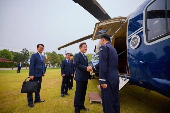 전용 헬기 탑승하는 李 대통령 - 이재명 대통령이 지난 13일 용산 대통령실 청사에서 전용 헬기에 탑승하기 전 승무원과 악수하고 있다. 왼쪽은 권혁기 의전비서관. 이 대통령은 이 사진을 14일 소셜미디어(SNS)를 통해 공개했다. 대통령실 제공