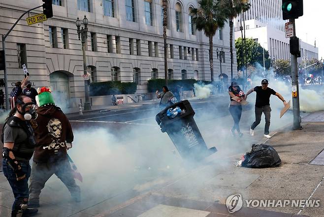 14일 LA 시청 앞 거리에서 최루탄으로 시위대를 해산시키는 경찰 [AFP=연합뉴스. 재판매 및 DB 금지]