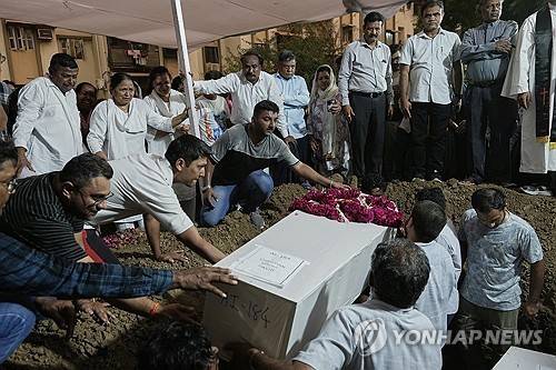 안장되는 인도 여객기 추락사고 희생자들 [AP 연합뉴스. 재판매 및 DB 금지]