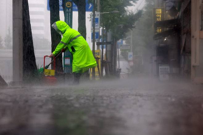 지난 16일 폭우가 쏟아진 서울 서대문구에서 환경미화원이 인도를 청소하고 있다. (사진=연합뉴스)