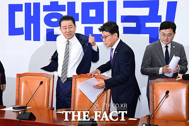 김병기 더불어민주당 대표 직무대행 겸 원내대표(왼쪽)가 17일 오전 서울 여의도 국회에서 열린 원내대책회의에서 발언에 앞서 외투를 벗고 있다. /국회=남윤호 기자