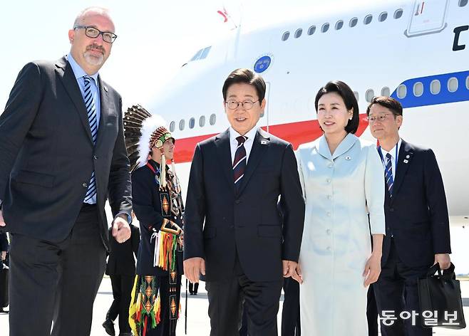 이재명 대통령과 김혜경 여사가 16일 (현지시간)  G7 정상회의에 참석하기 위해 캘거리공항에 도착해 세바스띠엥 까리에르(왼쪽) 캐나다 외교부 의전장의 안내를 받고 있다. 송은석 기자 silverstone@donga.com