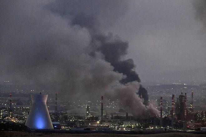 15일 이란의 미사일 공격 이후 연기가 피어오르는 이스라엘 하이파의 피해 시설 현장. 하이파/로이터 연합뉴스