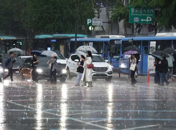 서울 광화문사거리에서 시민들이 우산을 쓴 채 횡단보도를 건너고 있다. [사진=연합뉴스]