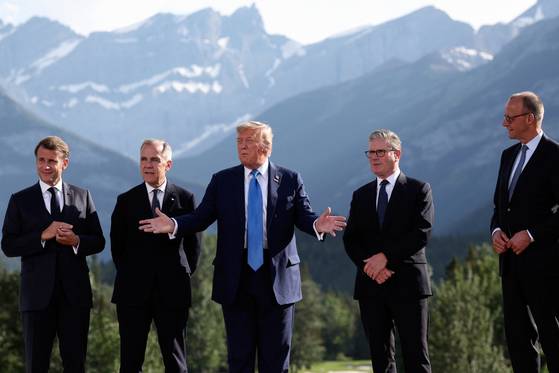 (왼쪽부터)에마뉘엘 마크롱 프랑스 대통령, 마크 카니 캐나다 총리, 도널드 트럼프 미국 대통령, 케이르 스타머 영국 총리, 프리드리히 메르츠 독일 총리가 16일(현지시간) G7 정상회의 기념 촬영을 위해 입장한 가운데 트럼프 대통령이 자신의 조기 귀국 결정에 관련한 발언을 하고 있다. AP=연합뉴스
