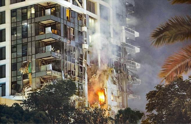 이란 미사일 공격을 받은 이스라엘 텔아비브의 한 건물에서 지난 13일 불길과 연기가 치솟고 있다.  AFP연합뉴스