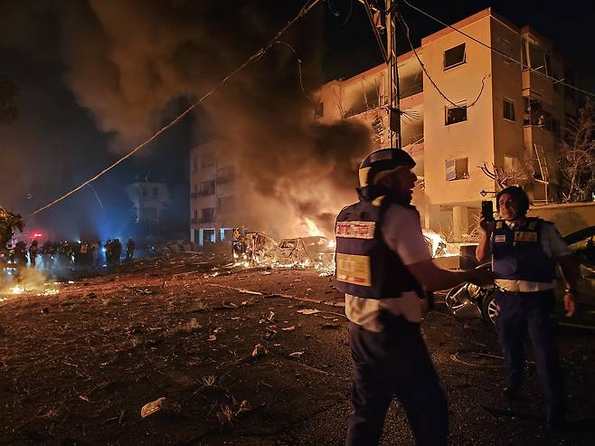 이스라엘 텔아비브의 구급대원이 16일 이란의 미사일 공격으로 화재가 발생한 곳에서 구조활동을 펼치고 있다.  UPI연합뉴스