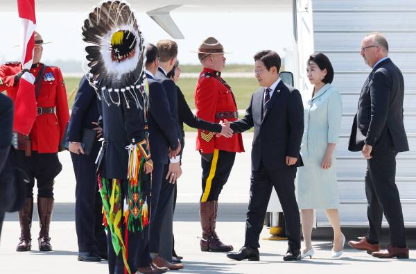 G7 정상회의에 참석하는 이재명 대통령이 16일(현지시간) 캐나다 앨버타주 캘거리국제공항에 도착해 영접 인사와 악수하고 있다. 연합뉴스