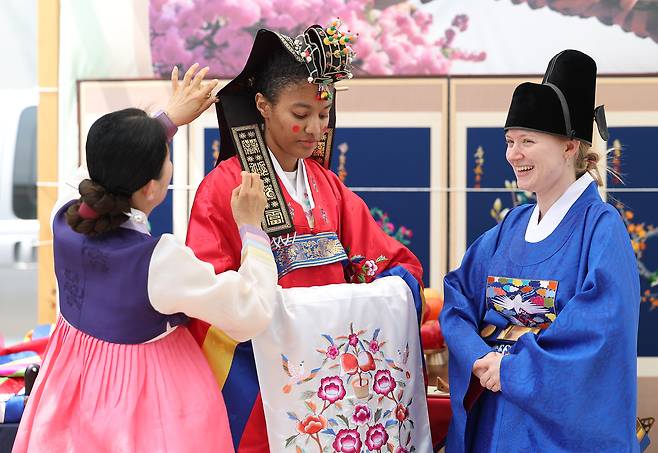 지난 7일 서울 종로구 청계광장에서 열린 북촌 공방 축제에서 외국인 관광객들이 전통혼례 체험을 하고 있다. [연합]