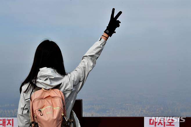 [광주=뉴시스] 이영주 기자 = 국립공원 지정 10주년을 맞아 무등산 정상 개방 행사가 열린 4일 오전 광주 무등산국립공원 지왕봉 전망대에서 한 시민이 희뿌연 광주 시내를 배경으로 기념사진을 찍고 있다. 2023.03.04. leeyj2578@newsis.com