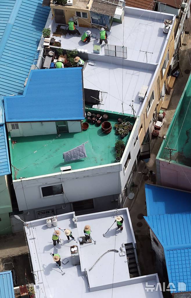[부산=뉴시스] 하경민 기자 = 부산시자원봉사센터와 7개 기업·기관, 대학생 자원봉사자 등 130여 명이 17일 부산 남구 문현2동 일대 주택 20여 곳의 옥상에서 쿨루프(Cool Roof) 열차단 페인트를 도포하는 봉사활동을 하고 있다.쿨루프는 태양열 반사 및 열 차단 효과가 있는 친환경 도료를 주택 지붕 및 옥상에 도포해 실내온도를 효과적으로 낮추는 기술이다. 2025.06.17. yulnetphoto@newsis.com
