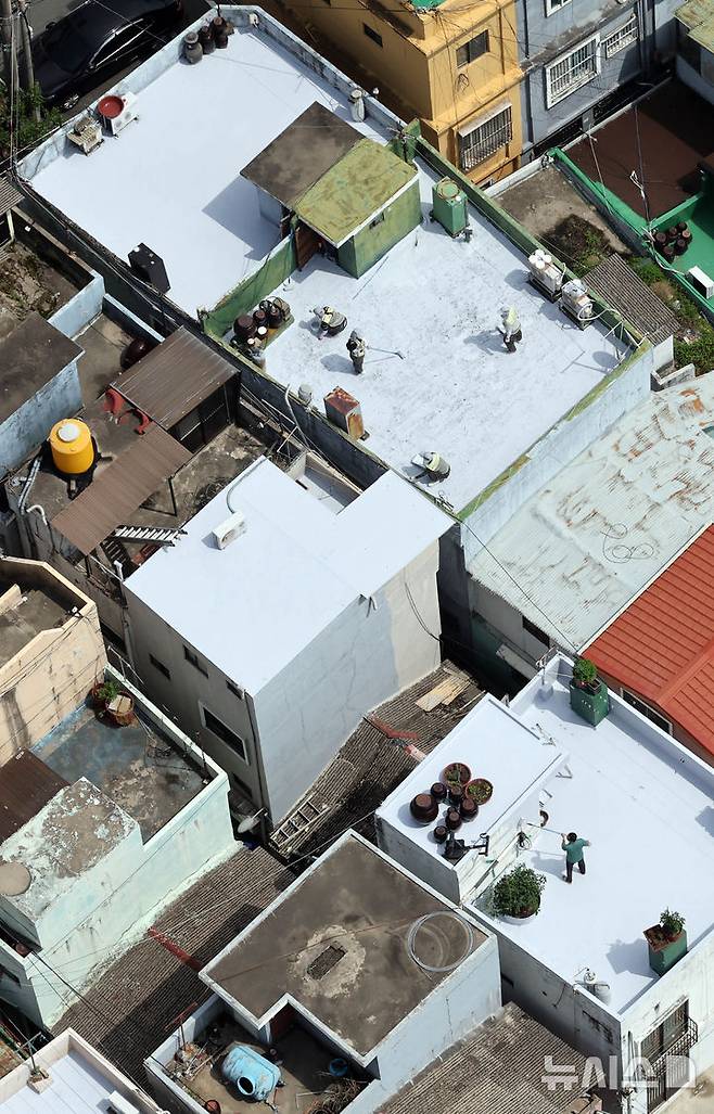 [부산=뉴시스] 하경민 기자 = 부산시자원봉사센터와 7개 기업·기관, 대학생 자원봉사자 등 130여 명이 17일 부산 남구 문현2동 일대 주택 20여 곳의 옥상에서 쿨루프(Cool Roof) 열차단 페인트를 도포하는 봉사활동을 하고 있다.쿨루프는 태양열 반사 및 열 차단 효과가 있는 친환경 도료를 주택 지붕 및 옥상에 도포해 실내온도를 효과적으로 낮추는 기술이다. 2025.06.17. yulnetphoto@newsis.com