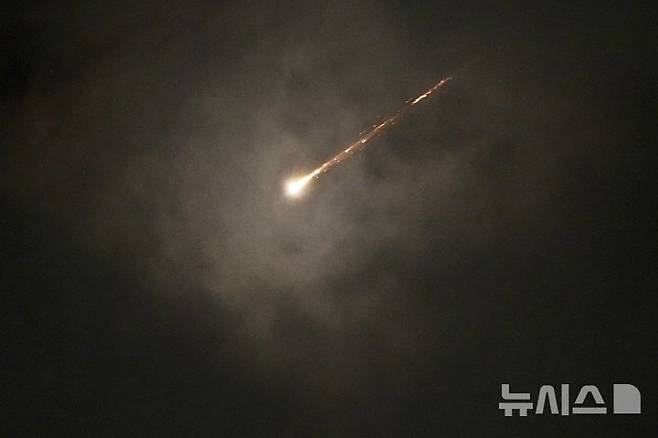 [예루살렘=AP/뉴시스] 16일(현지 시간) 예루살렘에서 이란의 미사일 발사에 따른 공습경보가 발령된 가운데 구름 사이로 발사체가 궤적을 그리며 비행하고 있다. 2025.06.17.