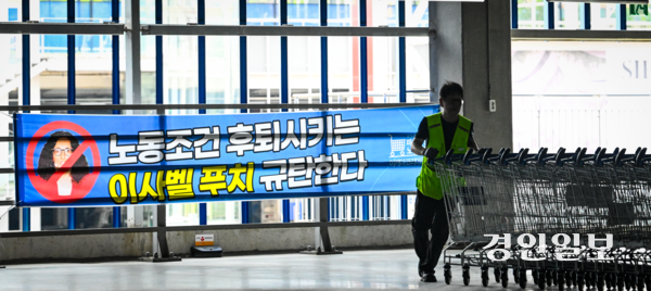 18일 경기도내 한 이케아 매장에서 카트를 옮기는 노동자 뒤로 이사벨 푸치 이케아코리아 대표를 규탄하는 현수막이 내걸려 있다. 2025.6.18 /이지훈기자 jhlee@kyeongin.com