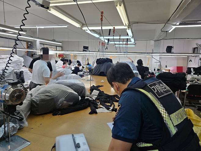 지난 9일 서울경찰청 기동순찰대가 서울 중랑구 망우동의 한 상가 건물에 있는 유명 의류 브랜드의 가품 제조공장을 단속하고 있다. 서울경찰청 제공