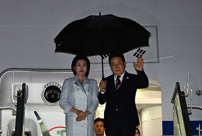 이재명 대통령과 부인 김혜경 여사가 17일(현지시간) 주요 7개국(G7)정상회의 일정을 마치고 캐나다 앨버타주 캘거리국제공항에서 공군 1호기에 탑승하며 손 인사를 하고 있다. / 사진=대통령실사진기자단