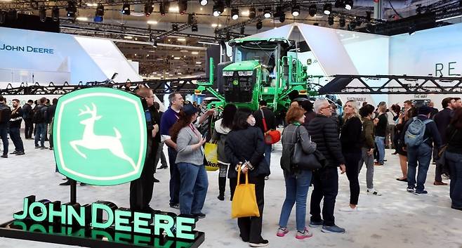 CES 2023의 존디어 전시관에서 관람객들이 자율주행 트랙터 및 센서 인공지능(AI) 기술 등을 이용한 해충 자동 박멸 기술을 살펴보고 있다. 사진=한국경제신문