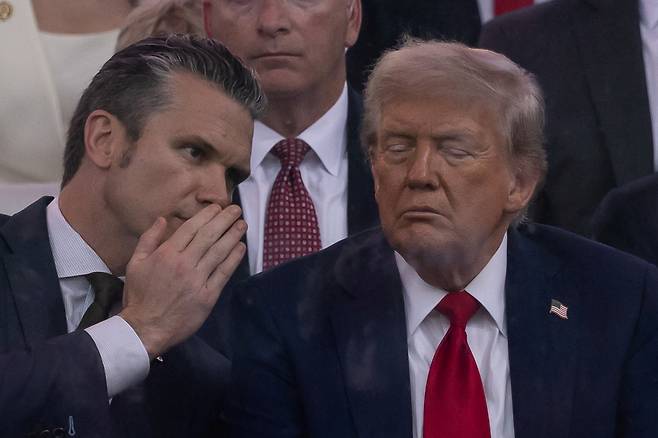 지난 14일(현지시간) 미국 워싱턴 D.C.에서 열린 미 육군 창설 250주년 퍼레이드에 피트 헥세스 미국 국방장관이 도널드 트럼프 미국 대통령에게 말하고 있다. 로이터연합뉴스