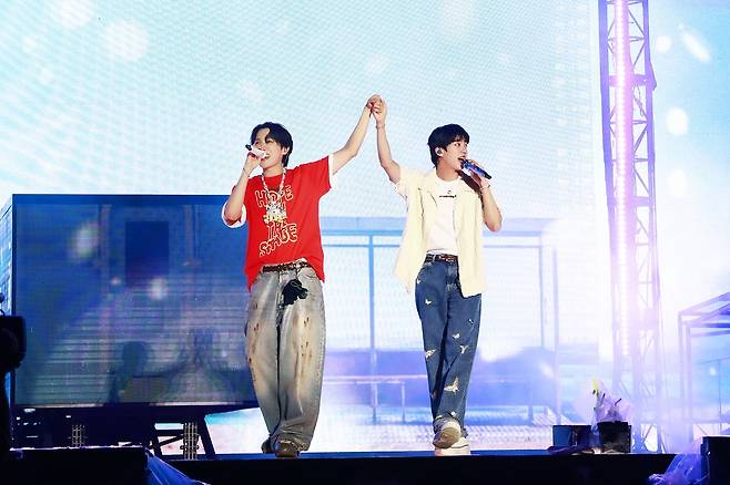 J-Hope (left) and Jin hold hands onstage during J-Hope's encore solo concert "J-Hope Tour 'Hope on the Stage' Final" at Goyang Sports Complex in Gyeonggi Province, Friday. (Big Hit Music)
