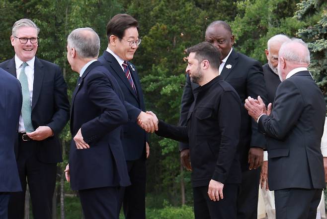 이재명 대통령과 볼로디미르 젤렌스키 우크라이나 대통령이 17일(현지시간) 캐나다 앨버타주 캐내내스키스 주요 7개국(G7) 정상회의장에서 G7 및 초청국 기념촬영 후 악수하고 있다.