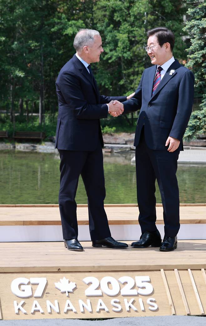 이재명 대통령이 17일(현지시간) 캐나다 앨버타주 캐내내스키스 주요 7개국(G7) 정상회의장에서 열린 초청국 공식 환영식에 도착해 의장국 마크 카니 캐나다 총리와 인사하고 있다.