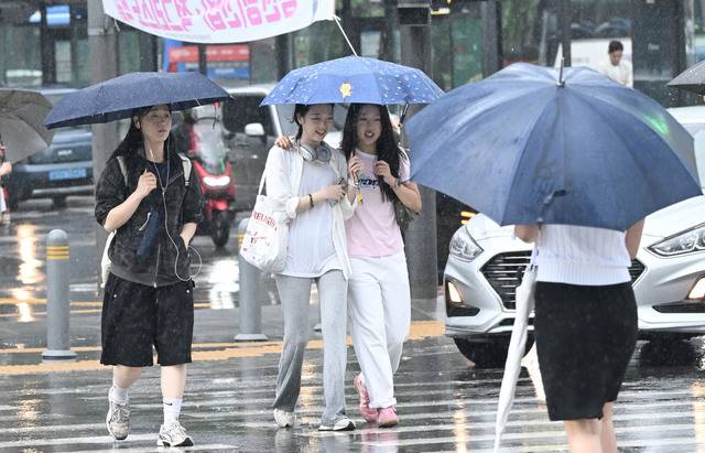 지난 16일 서울 종로구 광화문네거리에서 우산을 쓴 시민들이 내리는 비를 피해 발걸음을 재촉하고 있다. 권현구 기자