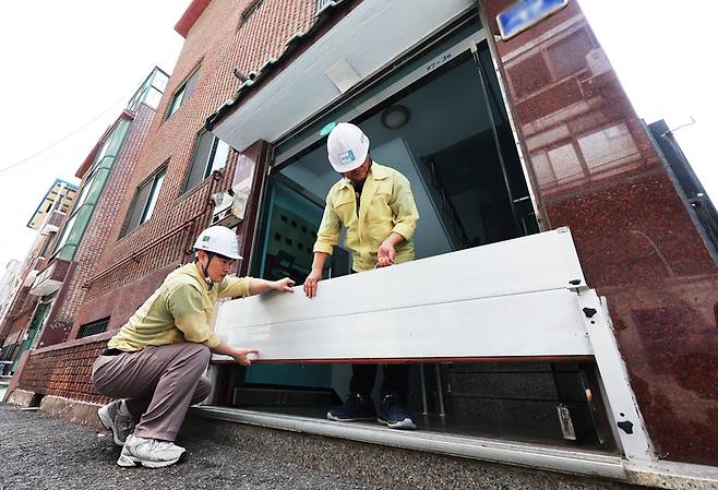 17일 경기도 군포시 산본동 주택가에서 군포시 공무원들이 차수판 등 반지하주택 침수방지시설을 점검하고 있다. [사진 = 연합뉴스]