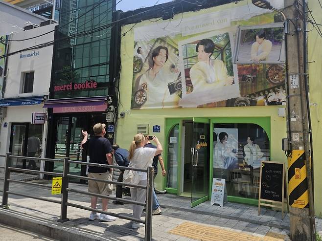 18일 오전 서울 용산구 하이브 사옥 인근 카페는 BTS(방탄소년단) 멤버의 사진이 찍힌 현수막를 내걸고 있었다. 지나가는 외국인 관광객들은 사진을 찍었고, 이내 매장 안으로 들어갔다./사진=박상혁 기자.