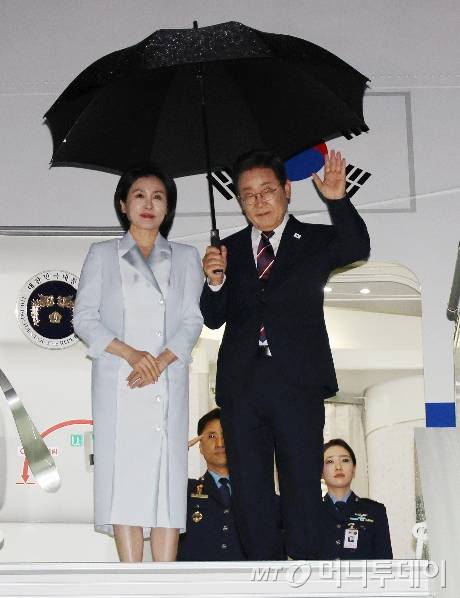 [캘거리=뉴시스] 주요 7개국(G7) 정상회의 참석을 마친 이재명 대통령과 부인 김혜경 여사가 17일(현지 시간) 캐나다 앨버타주 캘거리국제공항에 도착해 공군 1호기에 탑승하며 손을 흔들고 있다. 2025.06.18.