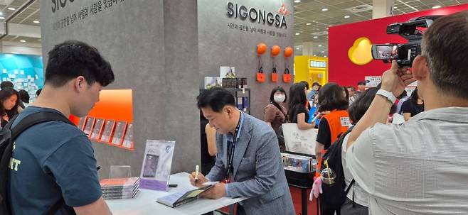 이광재 전 국회사무총장이 18일 서울 강남구 코엑스에서 열린 '서울국제도서전'에서 자신의 신간 '교황의 언어'를 처음 공개하고 출간 기념 사인회를 열고 있다.