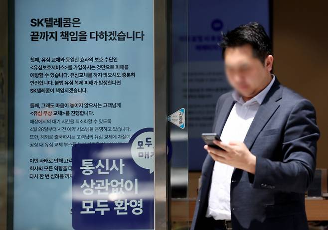 SK텔레콤이 최근 발생한 유심 해킹 사고를 악용한 스미싱·피싱 범죄가 잇따르고 있다며 이용자들에게 각별한 주의를 당부했다. 사진은 SK텔레콤 정보 유출 사고로 유심 대란이 지속되고 있는 지난 5월 서울 시내의 T월드 매장에 유심 교체 및 유심보호서비스 안내문이 게시되어 있는 모습. /사진=뉴시스