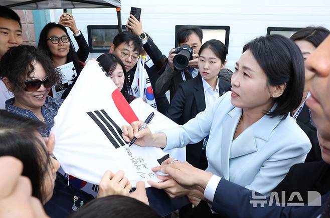 [캘거리=뉴시스] 최진석 기자 = 이재명 대통령 부인 김혜경 여사가 17일(현지 시간) 캐나다 앨버타주 캘거리 한인회관에서 열린 캐나다 서부 동포사회와의 대화를 나누기 전 동포들과 인사를 나누며 태극기에 싸인하고 있다. 2025.06.18. myjs@newsis.com