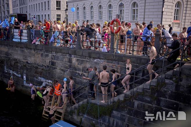 [베를린=AP/뉴시스] 17일(현지 시간) 독일 베를린 슈프레강에서 시민들이 수영 금지 해제를 촉구하며 수영하기 위해 이동하고 있다. 슈프레강은 수질 오염에 따른 보건 위험으로 100년 넘게 수영이 금지됐으며 강물과 분리된 부유식 수영장만 운영되고 있다. 시민 주도 비영리단체 '플루스바트 베를린'은 슈프레강이 수영할 만큼 수질이 개선됐다면서 수영 허용을 촉구하고 있다. 2025.06.18.